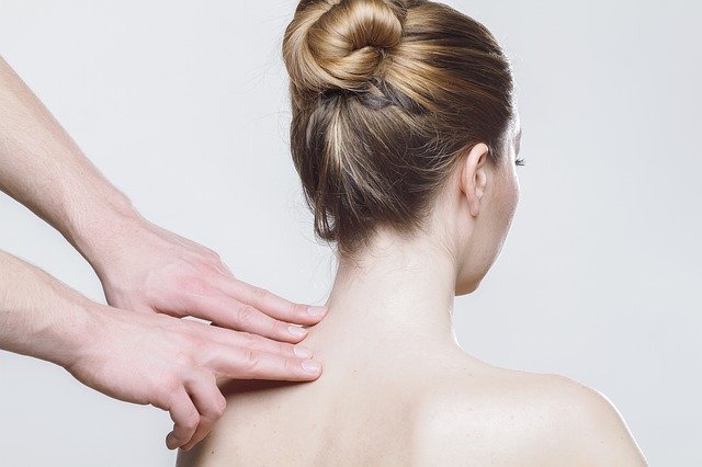 woman's shoulder being palpated